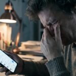 Usuário frustrado e estressado segurando o celular que exibe a mensagem de erro sem conexão Wi-Fi na tela.