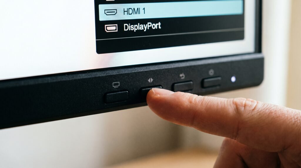 Usuário pressionando os botões do monitor para selecionar manualmente a porta de entrada HDMI.