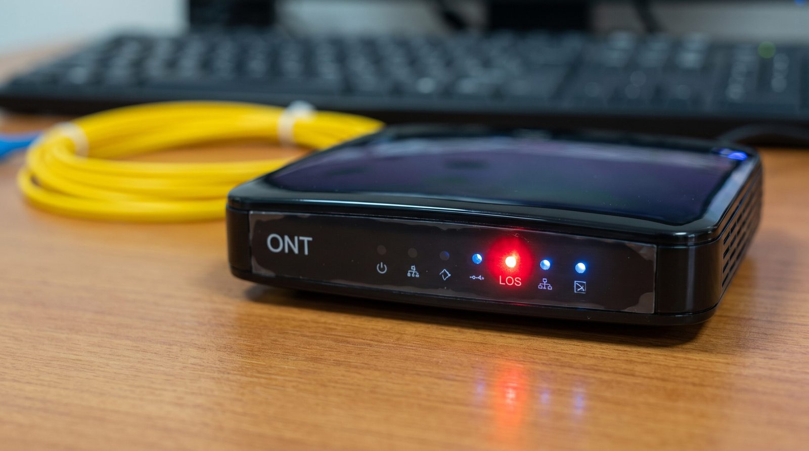 Painel frontal de um modem de fibra óptica mostrando a luz LOS vermelha piscando, indicando rompimento grave do cabo de internet na rua.