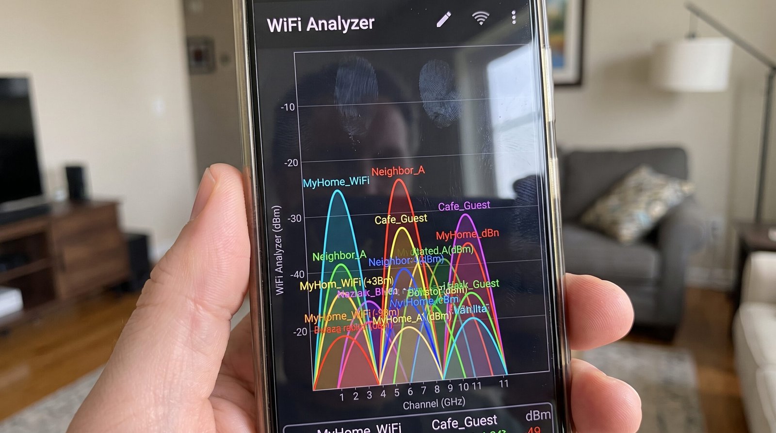 Tela de um smartphone mostrando o aplicativo WiFi Analyzer com gráficos de canais congestionados para identificar interferência de rede.