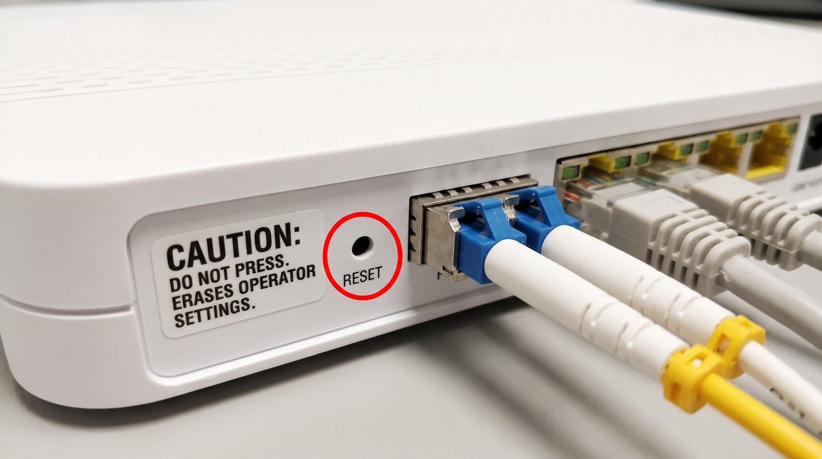 Botão Reset traseiro do roteador de fibra óptica que não deve ser pressionado para evitar apagar as configurações da operadora