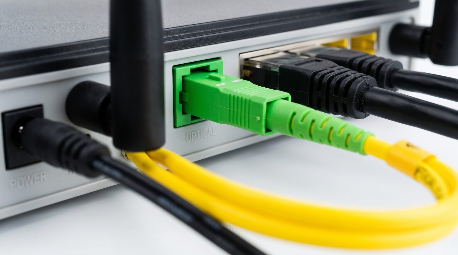 Parte traseira do roteador mostrando o cabo amarelo de fibra óptica com conector verde encaixado na porta óptica