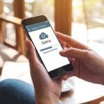 Usuário utilizando o celular para restaurar fotos apagadas através do backup em nuvem e da galeria